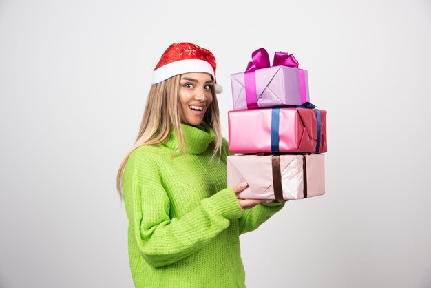 Gratis foto jonge vrouw met veel feestelijke kerstcadeautjes.