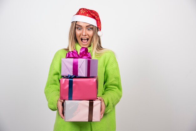 Jonge vrouw met veel feestelijke kerstcadeautjes.