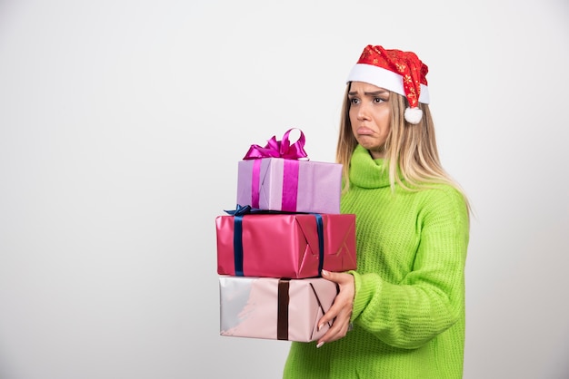 Jonge vrouw met veel feestelijke kerstcadeautjes