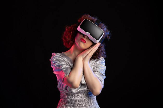 Jonge vrouw met virtual reality headset op donkere ondergrond