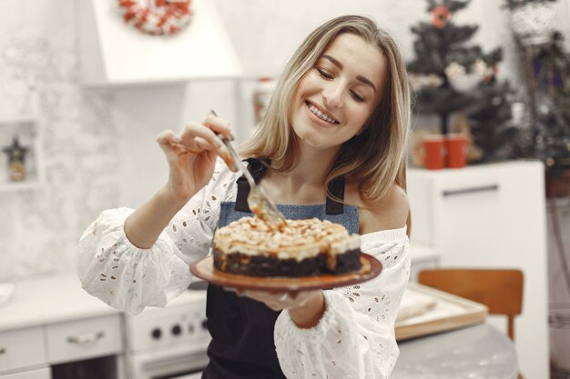 Jonge vrouw met zelfgemaakte cake in de keuken