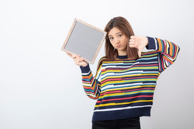 jonge vrouw model permanent en wijzend op een frame.