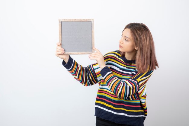 Jonge vrouw model staan en houden een frame.