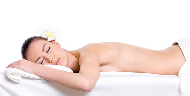 Jonge vrouw ontspannen voor massage - witte achtergrond - schoonheidsbehandeling therapie