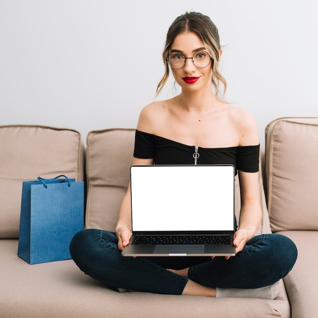 Jonge vrouw op bank met laptop model