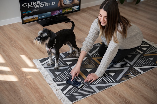 Gratis foto jonge vrouw op een mat met haar hond