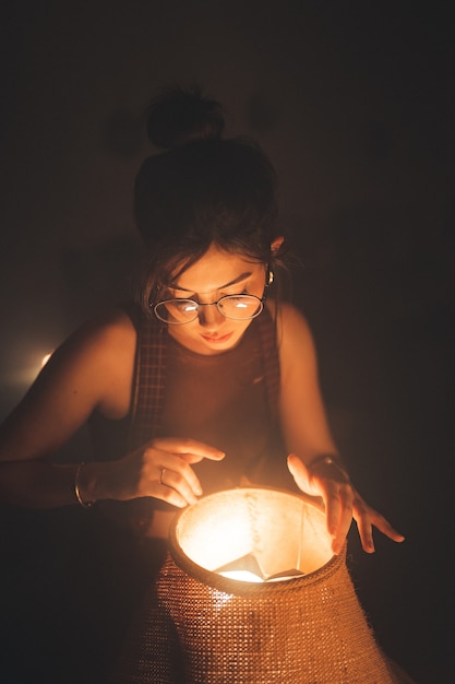 Gratis foto jonge vrouw op zoek naar een lamp