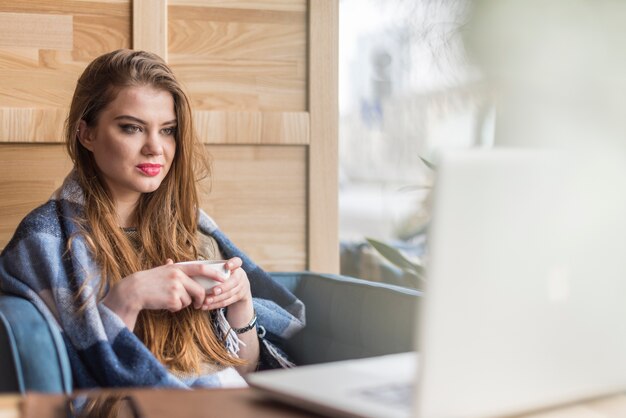 Jonge vrouw op zoek naar haar laptop scherm