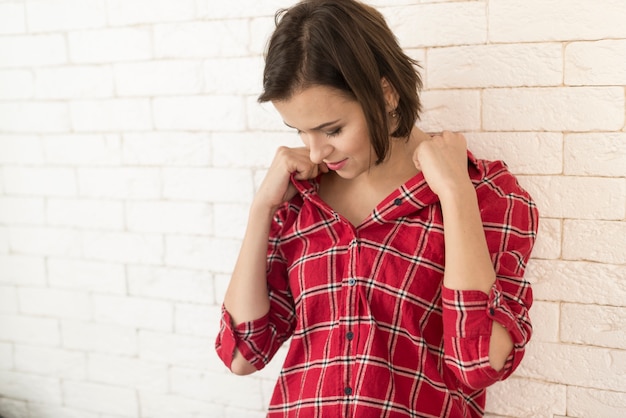 Gratis foto jonge vrouw op zoek naar haar shirt