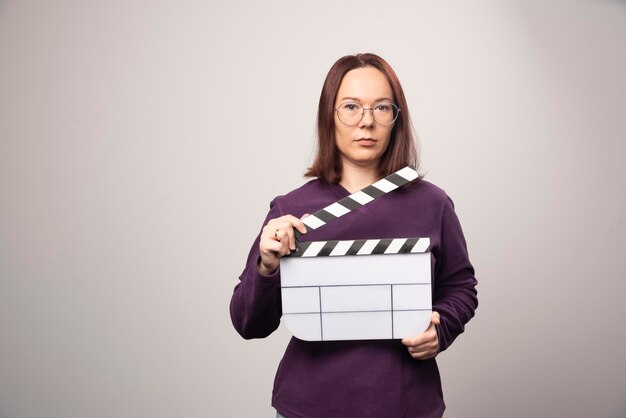 Jonge vrouw poseren met een bioscoopband op een wit. Hoge kwaliteit foto