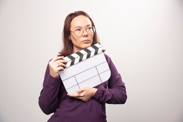 Jonge vrouw poseren met een bioscoopband op een wit. Hoge kwaliteit foto