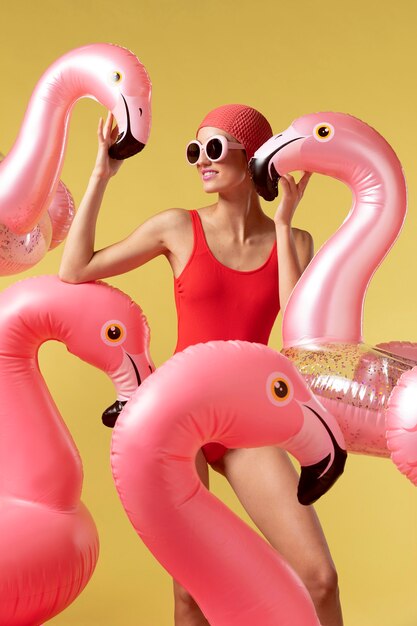 Jonge vrouw poseren met flamingo zwemmende ring