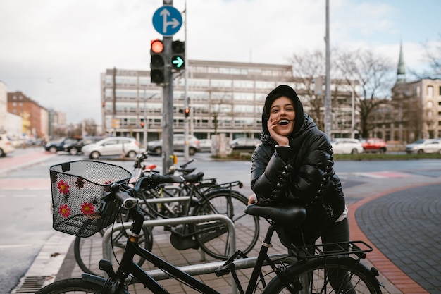 Jonge vrouw poseren op een parkeerplaats met fietsen