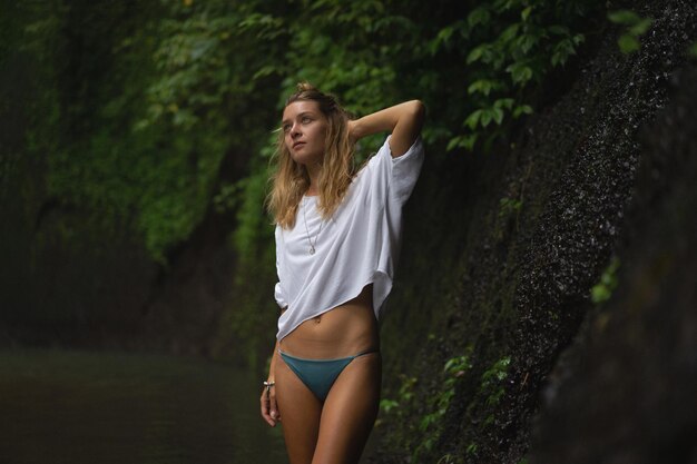 jonge vrouw reist het eiland rond en maakt foto's bij een waterval