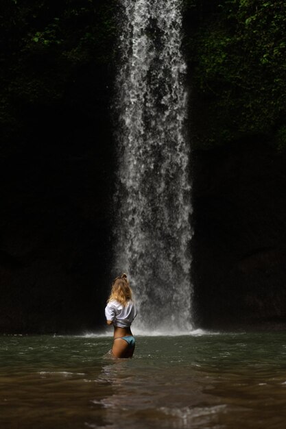 jonge vrouw reist het eiland rond en maakt foto's bij een waterval