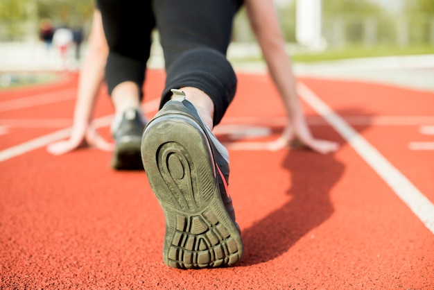 Gratis foto jonge vrouw runner zich klaar voor een run op het goede spoor