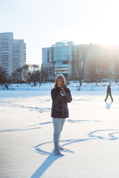Jonge vrouw schaatsen, wintersport, sneeuw, winterpret. Vrouw leert schaatsen op het meer, de natuur, de zonnige dag.