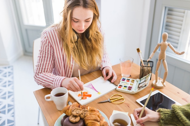 Jonge vrouw schilderij in schetsboek