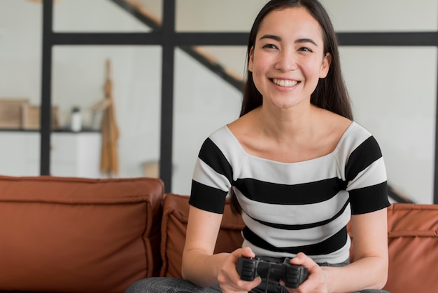 Gratis foto jonge vrouw spelen met joystick