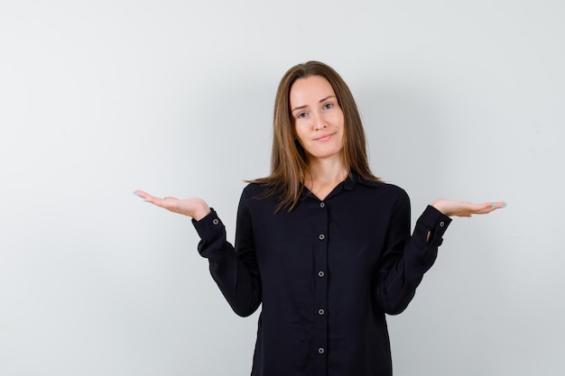 Jonge vrouw spreidt handpalmen opzij