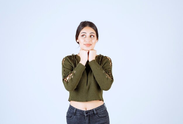 Jonge vrouw staat en droomt over gelukkige herinneringen.