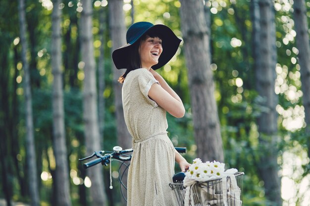 Jonge vrouw tegen aardachtergrond met fiets