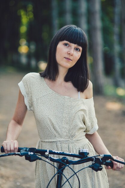 Jonge vrouw tegen aardachtergrond met fiets