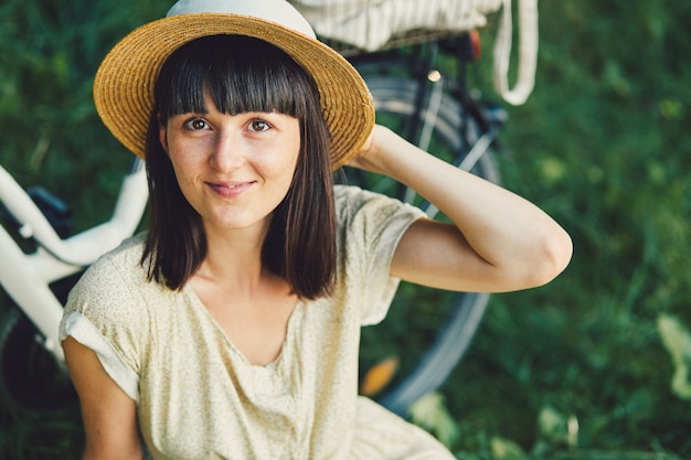 Jonge vrouw tegen aardachtergrond met fiets