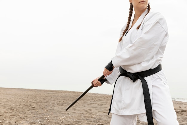 Jonge vrouw training in karate outfit