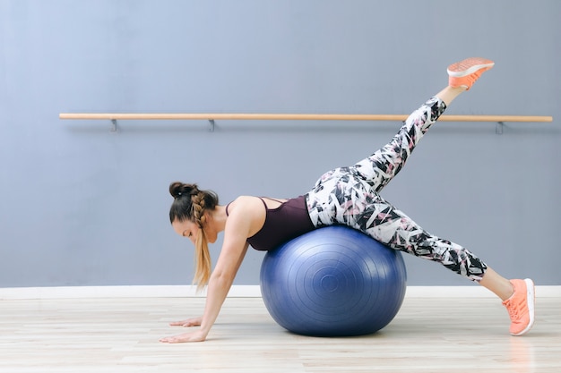 Gratis foto jonge vrouw training op fitball