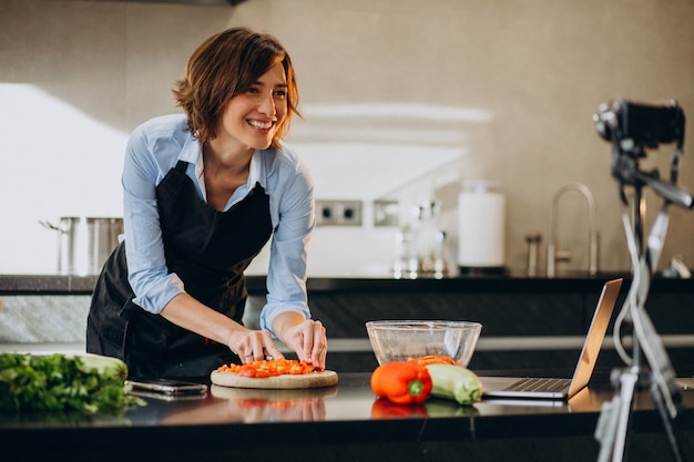 Gratis foto jonge vrouw videoblogger koken in de keuken en filmen