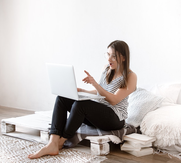 jonge vrouw werkt op afstand op een computer thuis.