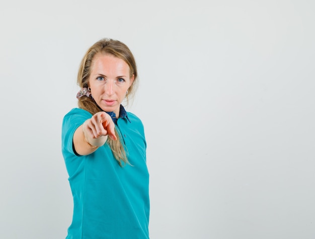 Gratis foto jonge vrouw wijzend op camera in t-shirt en op zoek naar doorslaggevend.