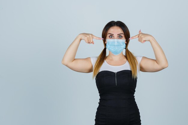 Jonge vrouw wijzend op masker