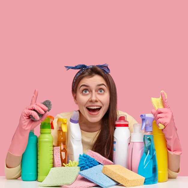 Jonge vrouw zit naast schoonmaakmiddelen