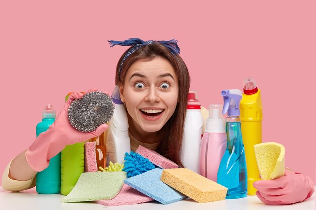 Jonge vrouw zit naast schoonmaakmiddelen