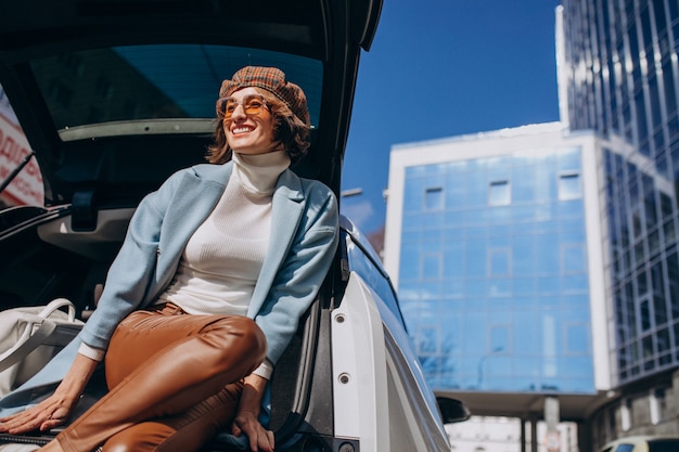 Jonge vrouw zitten in de achterkant van de auto praten aan de telefoon