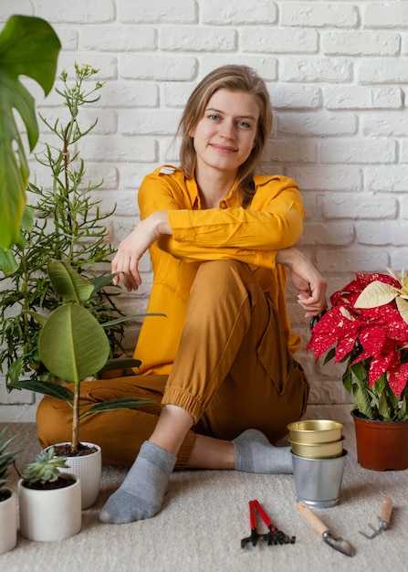 Jonge vrouw zittend op de vloer van haar huis tuin