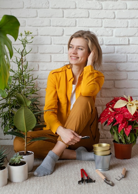 Jonge vrouw zittend op de vloer van haar huis tuin