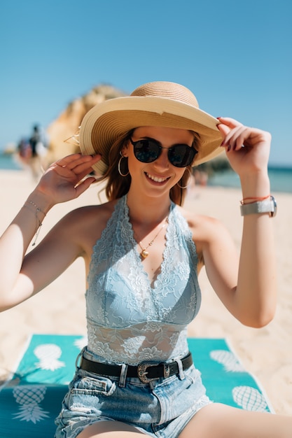 Jonge vrouw zittend op het strand