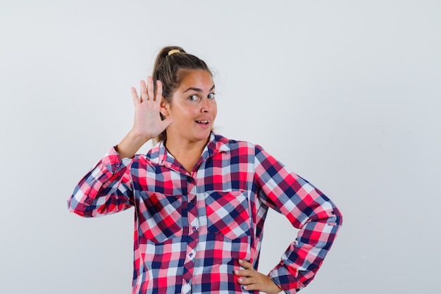 Gratis foto jonge vrouw zwaaiende hand om afscheid te nemen in casual overhemd en op zoek gelukkig. vooraanzicht.