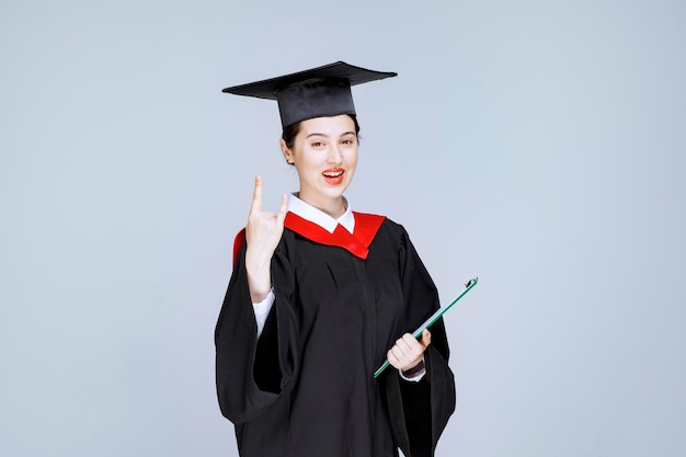 Jonge vrouwelijke afgestudeerde student met diploma. Hoge kwaliteit foto