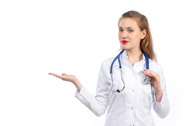 jonge vrouwelijke arts in witte medische pak met een stethoscoop op de witte