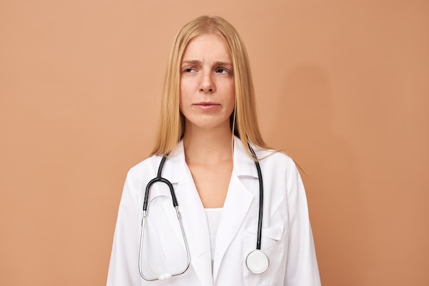 Jonge vrouwelijke arts met sluik blond haar en een stethoscoop om haar nek