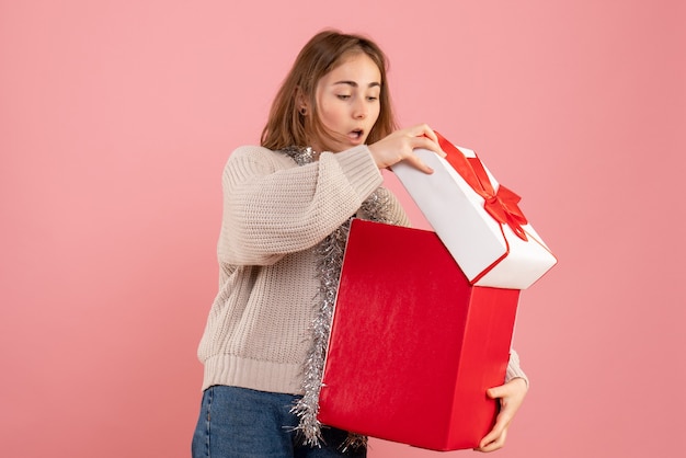 jonge vrouwelijke bedrijf xmas huidige doos op roze