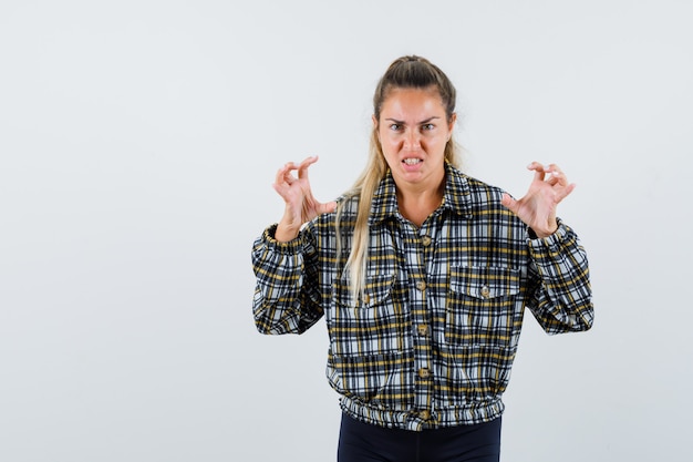 Gratis foto jonge vrouwelijke hand in hand op agressieve manier in shirt, korte broek vooraanzicht.