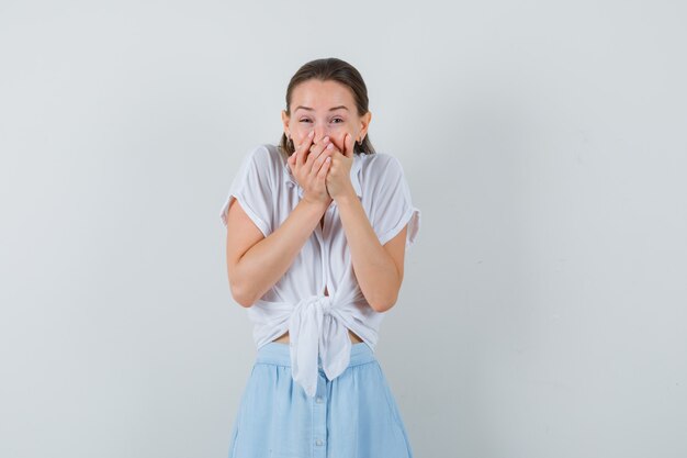 Jonge vrouwelijke hand in hand op de mond terwijl lachen in blouse en rok vooraanzicht.