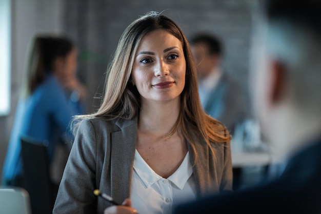 Gratis foto jonge vrouwelijke ondernemer die met een collega praat terwijl hij op kantoor is