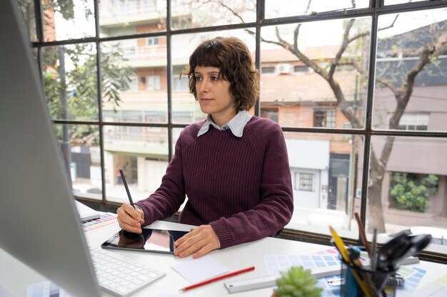 Jonge vrouwelijke ontwerper die aan een project werkt