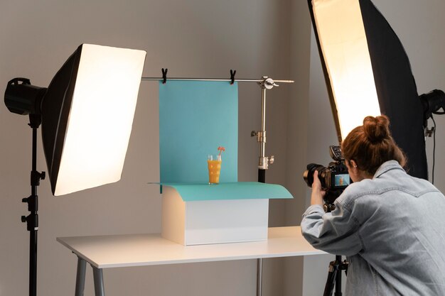 Jonge vrouwelijke productfotograaf in studio